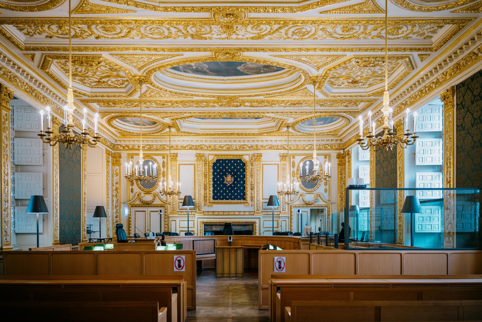 Une salle d'audience de cour d'assises, ornée de détails dorés et de lustres, à Rennes, en France.